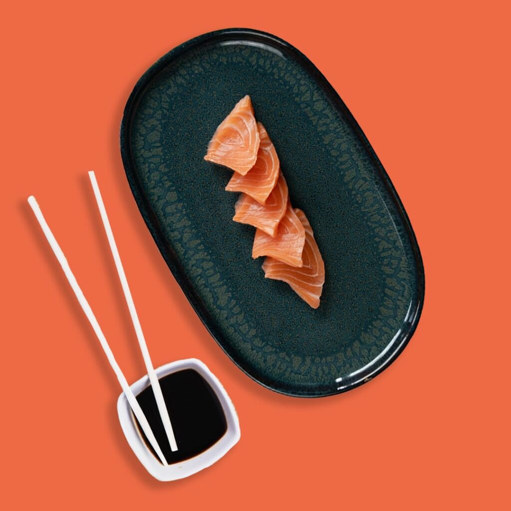 Sashimi de saumon frais coupé en tranches fines, présenté avec soin - une spécialité halal de Tastyrice.